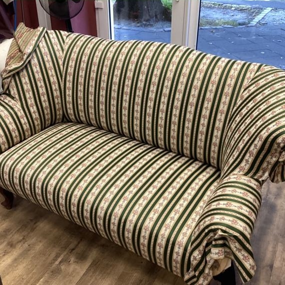 Der ausgesuchte gestreifte Stoff liegt lose über dem Sofa, noch ungeschnitten